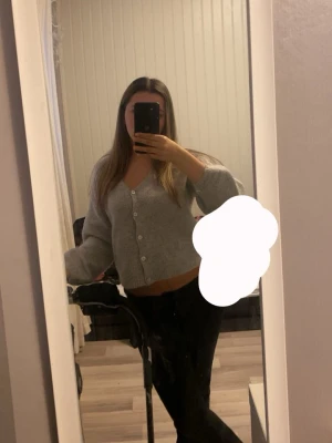 Grå cropped kofta med knappar - Mysig grå kofta med v-ringning och vita knappar framtill. Storlek Xs men passar mig som oftast har S, använd några gånger men är i mycket bra skick!!💕