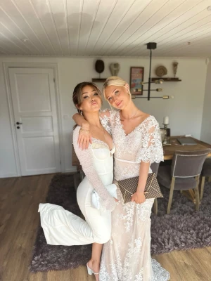 Lång vit spetsklänning med v-ringning - Elegant långklänning i vit spets med v-ringad hals och korta, vida ärmar. Klänningen har fina broderade spetsdetaljer och transparenta partier som ger en lyxig känsla. Perfekt för speciella tillfällen och baler! (Pris kan diskuteras) 