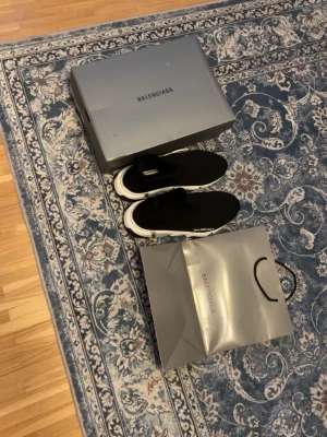 Balenciaga Speed sneakers svarta - Svarta Balenciaga Speed sneakers med vit sula och stickad ovandel. Skorna har en strömlinjeformad design och logotypen på sidan. Materialet är stretchigt och bekvämt, perfekt för en modern och clean look.