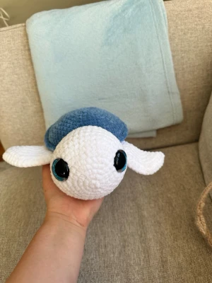 Virkad sköldpaddsmjukis blå och vit - Supergullig handvirkad sköldpadda i mjukt garn. Skölden är blå och kroppen är vit, med stora blå ögon. Perfekt som dekoration eller gosedjur. 