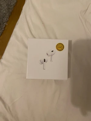 Apple AirPods Pro trådlösa hörlurar - Säljer ett par vita Apple AirPods Pro med aktiv brusreducering och laddningsetui. Hörlurarna är kompakta, har silikonproppar och levereras i originalförpackning. Perfekta för musik, samtal och gaming. Stilren design i plast och smidig att ta med överallt.
