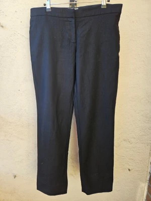 Stella McCartney kostymbyxor - Svarta kostymbyxor från Stella McCartney i fint skick. Två fickor fram och en stängd ficka på baksidan. Står storlek 44 men skulle snarare säga att den passar ca 38-40.