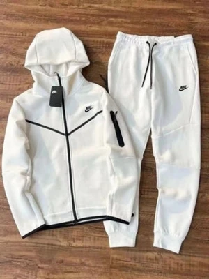 Nike tracksuit  - Snyggt beige loungewear set från Nike med hoodie och matchande byxor. Hoodien har svarta detaljer, dragkedja och fickor, samt Nike-logga på bröstet. Byxorna har resår i midjan, svarta snören och Nike-logga på benet. Perfekt för chill dagar hemma.