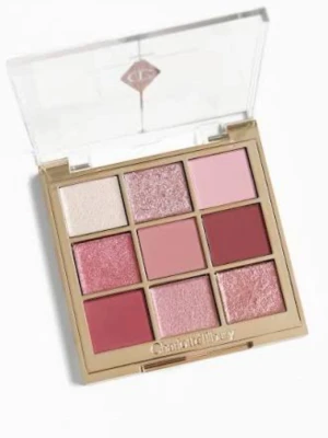Charlotte Tilbury ögonskuggspalett rosa - Säljer en ögonskuggspalett från Charlotte Tilbury med nio nyanser i rosa, vinrött och champagne. Paletten innehåller både matta och skimrande skuggor i fyrkantiga pans, perfekt för kreativa sminkningar. Lyxig guldram och genomskinligt lock med logga.