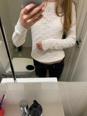 Vit stickad tröja med hålmönster - Säljer en vit stickad tröja med snyggt hålmönster och rund hals. Har använt ett fåtal gånger.