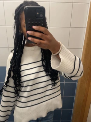 Vit stickad tröja med svarta ränder -  Mjuk stickad tröja som är jätteskön att ha på sig, har svarta ränder och är långärmad