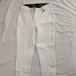 RIDBYXA CRW  - Vita ridbyxor. HELT OANVÄNDA RIDBYXOR  i nytt skick. Snygga ridbyxor! Kardborre längst ner på byxbenen. Byxorna har inte prislappen kvar.