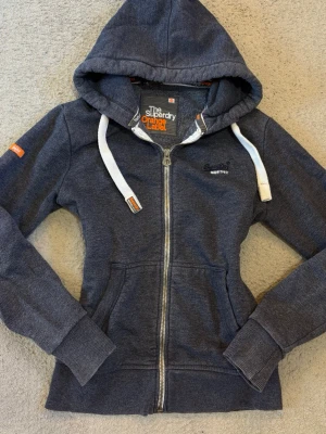 Superdry vintage mörkblå zip hoodie M - Vintage mörkblå hoodie från Superdry Orange Label med dragkedja och broderad logga framtill.  I fint skick💕