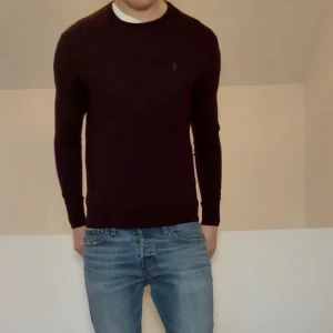 Ralph Lauren Merino ulltröja - Säljer en nice vinröd Ralph Lauren trlja i färgen vinröd. Tröjan är i bra skick förutom 2 jätte jättesmå hål på framsidan som endast syns ifall man stretchar ut tröjan. Tröjan är gjord i 100% Merino ull och hör gärna av er vid frågor elr funderingar!! Den sitter även i strl S!