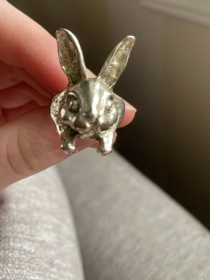 Silvrig ring med kaninform - Unik ring i silverfärgad metall formad som ett kaninhuvud med utstickande öron och detaljerat ansikte. Perfekt för dig som gillar djur och vill ha ett statement-smycke som sticker ut i mängden.