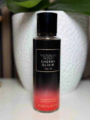 Victoria's Secret Cherry Elixir mist - En snygg parfymmist från Victoria's Secret i doften Cherry Elixir No. 33. Flaskan är svart med en röd toning nedtill och har en elegant svart kork. Rymmer 250 ml och är perfekt för dig som gillar fruktiga och söta dofter.