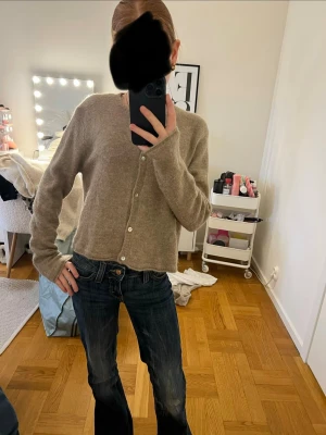 Brun/beige kofta - Mysig beige kofta med långa ärmar och knäppning framtill. Koftan passar perfekt till jeans eller kjol. Enkel design som funkar till många outfits.