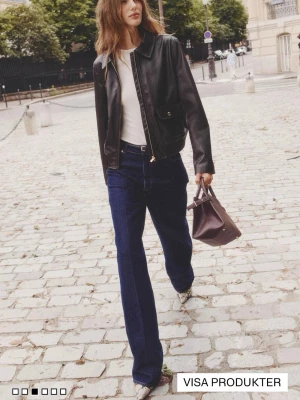 Mörk brun skinnjacka med klassisk design - Snygg mörk brun skinnjacka med rak passform och krage. Jackan har dragkedja framtill, ficka med lock och ribbade muddar vid nederkant. Perfekt för dig som vill ha en tidlös och cool look. 💛💛