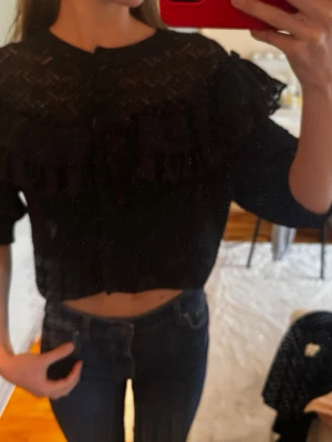 Svart volangkofta med spetsdetaljer - Kort bolero med volang.