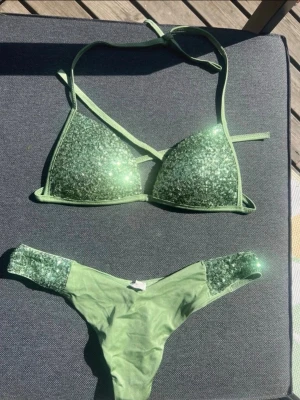 Calzedonia bikini 💚 - * Grön glittrig bikini från calzedonia i den populära Coby modellen, som inte görs längre. * Båda delarna är i storlek M * Toppen är “stadig” och ger support * Trosorna är Brazilian med en v-skurning i fram vilket ger en jättefin siluett * Nyskick och oanvänd!! 🌴