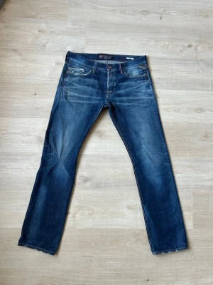 Blåa Barcelona x Replay Waitom Jeans W34 L34 - Fina Replay Jeans i blå färg. Jeansen är i mycket bra skick och sparsamt använda. |  Äkta som allt annat jag säljer! ✅ |  Storlek: W34 L34 | Skick: Mycket Bra Skick - Tyvärr blivit lagade på ett ställe (SE SISTA BILD) | Färg: Blå | Märke: Replay | Modell: Jeans |   Hör gärna av dig vid frågor så svarar jag så fort jag kan! 😁 |  (SKU - 110)
