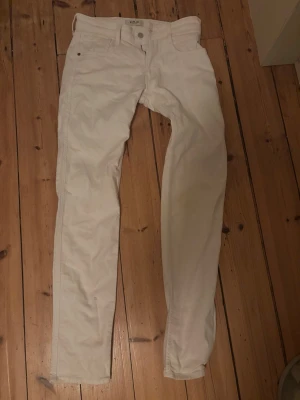 Vita slim fit jeans från Replay - Snygga vita jeans från Replay i slim fit-modell. Använt 1 gång, men jeansen blev lite smutsiga som man ser på det högra knät, men går säkert bort om man använder lite bättre medel. Storlek 30/34
