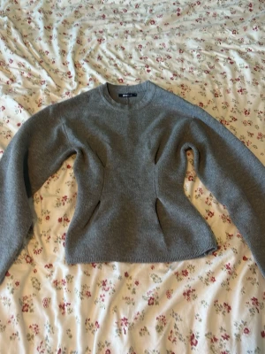 Grå figursydd stickad tröja Zara - Snygg grå stickad tröja från Zara med figursydd passform och rund halsringning. Tröjan har långa ärmar och markerade sömmar som ger en cool siluett. Perfekt för dig som gillar stilrena och trendiga plagg.