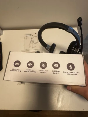 Trådlöst headset med mikrofon - Snyggt svart och silverfärgat trådlöst headset med brusreducerande mikrofon, kontroll- och mute-knapp samt laddkabel. Lättvikt och upp till 26 timmars batteritid. Perfekt för gaming, samtal eller musik. Sitter bekvämt med justerbar bygel och mjuka öronkuddar.