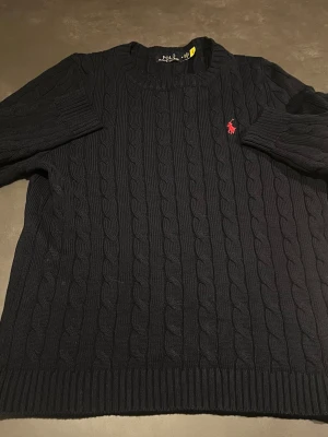 Stickad Ralph Lauren tröja - En riktigt snygg marinblå tröja från Ralph Lauren, helt ny aldrig använd, riktigt fet till vår/sommar🔥