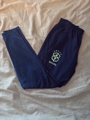 Nike Brasilien byxor marinblå - Byxor till ett marinblått Nike Brasilien sätt. Träningsbyxor med slim fit passform i ett bra skick. Hör av er vid frågor😃