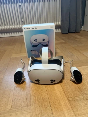 Meta Quest 3S VR-headset med kontroller - Meta Quest 3S VR-headset i vit färg med matchande kontroller. Snygg och modern design med mjuka former och justerbart huvudband. Tillverkad i plast och textil för bekväm användning. Perfekt för gaming och VR-upplevelser.