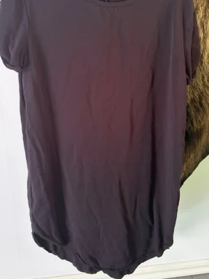 Mörk lila T-shirt från Divided H&M - En sportig lila t-shirt från Divided by H&M. Tröjan har rund halsringning, korta ärmar och är gjord i mjukt bomullsmaterial. Perfekt för en avslappnad och sportig stil.
