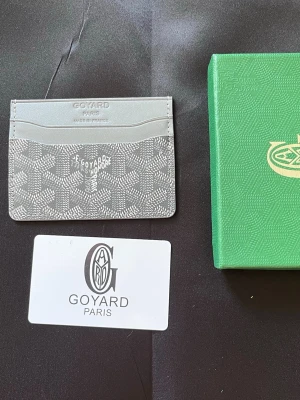 Grå kortfodral - Snyggt och stilrent grått kortfodral med klassiskt mönster och präglad logotyp. Tillverkat i exklusivt läder med flera kortfack. Perfekt för dig som vill ha en tunn och smidig plånbok med lyxig känsla.