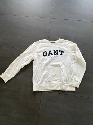 Vit sweatshirt från GANT - Vit sweatshirt från GANT med mörkblå logga och texten 'Est. 1949' på bröstet. Mycket bra skick:)