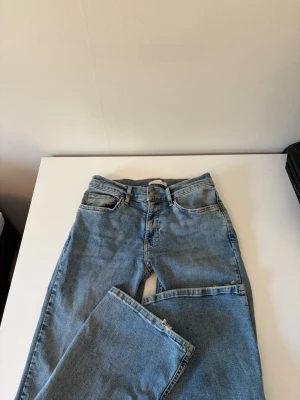 Ljusblå bootcut jeans från Ginatricot  - Säljer ett par klassiska ljusblå jeans från ginatricot med bootcut passform och hög midja. Endast andvända ett par gånger.