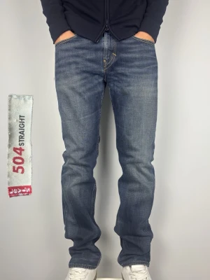 Levis 504 Straight Vintage Jeans - Levis 504 straight. Rak passform. Väldigt schyssta vintage jeans. Skick: A Grade, perfekt skick!  Färg: Mörkblå med fades | Modell: 504 Straight | Storlek: W33 L34 | Premium Jeans. Passar bra på killen i bilden som är 189 cm.   Mått: (Måttavvikelse +-1cm) A: 42,5 cm B: 110 cm C: 20 cm D: 30 cm  Tveka inte att höra av dig minsta fråga eller fundering!  Skickas snabbt!