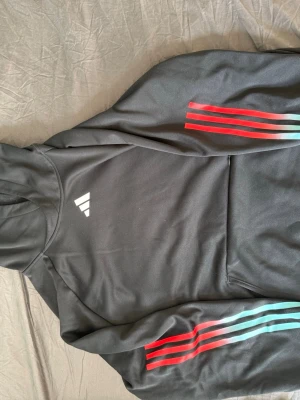 Adidas hoodie - Adidas hoodie som kan användas till antingen under träning eller som vardagsklädsel då den är ganska tunn och lätt att ha på sig när man t.ex. springer eller gymmar