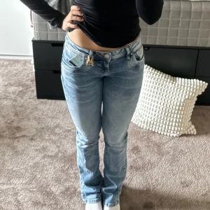 Ljusblå bootcut jeans låg midja - Säljer ett par ljusblå jeans med bootcut och låg midja. Jeansen har klassisk femficksdesign, snygg tvätt och raka ben som blir lite utsvängda nertill. Perfekta för en avslappnad och trendig look.