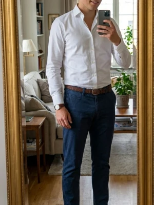 Mörkblå chinos med smal passform - Snygga mörkblå chinos med smal passform och klassisk design. Byxorna har sidofickor, bälteshällor och stängs med knapp och dragkedja. Perfekta för en stilren och avslappnad look. Tillverkade i mjukt bomullstyg som ger en bekväm känsla hela dagen.