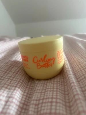 Umberto giannini curling butter - Säljer en curling butter/leave in conditioner från Umberto Gianinni. Kan användas som en curling cream. Passar alla typer av lockar men passar bättre till 3b-4b. Är en tjockare konsestens och är återfuktande. Använd endast en gång och finns jätte mycket kvar.