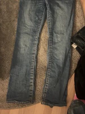 True Religion bootcut jeans blå - Säljer mina super snygga true religions byxor för de är för stora! De är i storlek 30 och är lite trasiga där nere vid ena benet skriv gärna om ni har några frågor 🤗