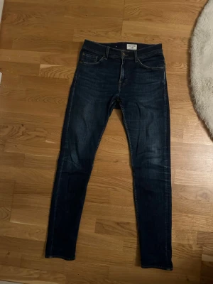 Tiger of sweden jeans  - Säljer ett par mörkblå jeans från tiger of sweden med klassisk femficksdesign och smal passform. Jeansen har snygga slitningar och är tillverkade i stretchigt denimtyg för extra komfort. Perfekta till en avslappnad look. W29 L32