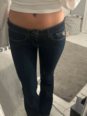 Mörkblå bootcut jeans med låg midja - Snygga mörkblå jeans med låg midja och bootcut passform. Använda enstaka gånger! Nypris 1600kr