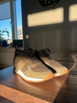 Olivgröna sneakers från EA7 - Snygga olivgröna sneakers från EA7 med meshpaneler och detaljer i mocka. Skorna har vita och gummifärgade sulor samt logga på sidan. Perfekta för dig som vill ha en sportig och stilren look. Pris kan sänks vid snabb affär🙌