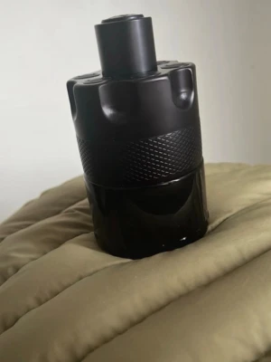 Azzaro The Most Wanted - Säljer en Azzaro Wanted By Night parfym i en cool, svart flaska med cylinderform och detaljer som påminner om en revolvertrumma. Flaskan är tillverkad i glas och metall med en matt och glansig finish. Perfekt för dig som gillar maskulina och unika dofter.