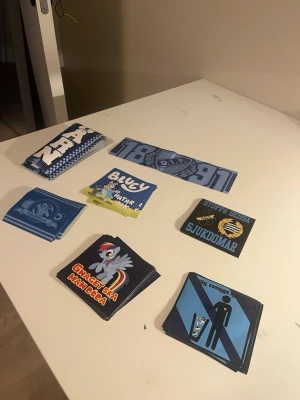 Stickers med Djurgården-tema - Säljer ett gäng klistermärken med Djurgården-tema i olika motiv och färger, mestadels blått och vitt. Motiven inkluderar text, loggor, tecknade figurer och supporterbudskap. Perfekt för att pimpa laptop, mobil eller cykel.
