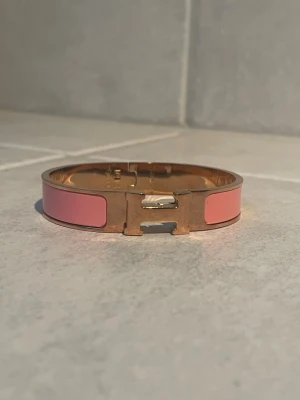 Armband - Snyggt armband med rosa detaljer. Armbandet är i mycket bra skick och har kvinnlig passform