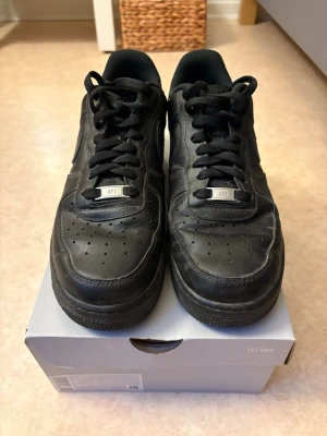 Nike Air Force 1 ’07 - Svarta Nike af1 i storlek 42,5, använda lite grann, de creasade snabbt.
