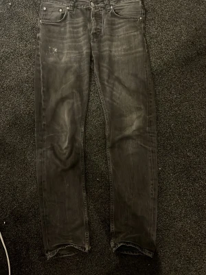 Svarta slim fit jeans - Säljer ett par svarta slim fit jeans med klassisk femficksdesign och diskreta slitningar. Jeansen har normal midja och raka ben, perfekta till en avslappnad streetwear-look. Materialet är mjukt denim som ger en skön känsla hela dagen.