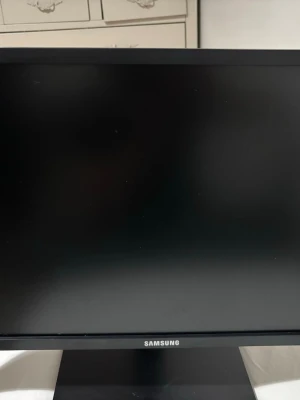 Samsung svart datorskärm - Säljer en stilren svart datorskärm från Samsung med rektangulär form och stabil fot. Skärmen har en tunn ram och mattsvart finish, perfekt för gaming eller studier. Baksidan har tydliga ventilationsränder och justerbart stativ i plast.