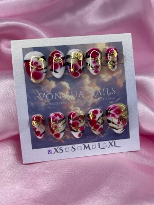 RubyKitty (S);Short Almond - Handgjorda press-on naglar med en unik design i rött, vitt och svart, dekorerade med guldfärgade HK detaljer. Naglarna har en kort mandelform och glänsande finish. Perfekt för dig som vill ha något extra till naglarna.S: 15 mm, 11,5 mm, 12 mm, 11 mm, 9 mm 