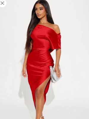 Röd offshoulder klänning med slits - Helt ny och aldrig använd stilren röd oneshoulder klänning i glansigt satinmaterial. Tjockt och bra material. Prislappen kvar och kommer i orderpåsen. 
