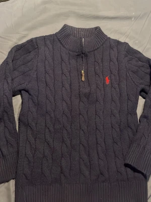 Ralph lauren tröja - Säljer en Ralph lauren kabelstickad quater zip. Den är sparsamt använd med i otroligt bra skick.  Den är i Stolek S men skulle säga att den passar Stolek XS