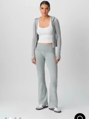 Grå bootcut yoga pants från Gina Tricot - Säljer ett par ljusgrå yoga pants med bootcut-modell från Gina Tricot. Byxorna har bred, vikbar linning och är tillverkade i mjukt stretchigt material som är riktigt skönt. Perfekta för chill eller träning. Mycket bra skick. Slutsålda på hemsidan!❣️