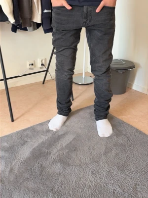 Svarta slim fit jeans - Säljer ett par svarta slim fit jeans med klassisk femficksdesign och normal midja. Jeansen har en snygg tvättad look och smal passform som sitter tajt längs benen. Perfekta för dig som gillar en stilren och modern vibe.